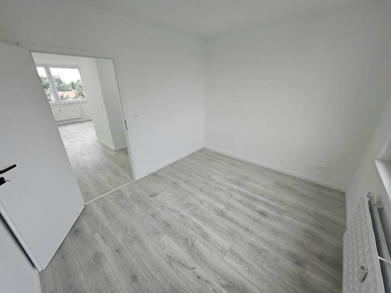 3 izbový byt Bánovce nad Bebravou / CENTRUM- STRED / 56 m2 / NOVÁ REKO - Svetlá miestnosť v 3-izbovom byte s laminátovou podlahou a otvorenými dverami.