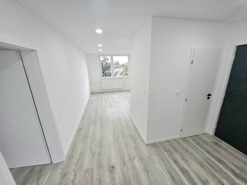 3 izbový byt Bánovce nad Bebravou / CENTRUM- STRED / 56 m2 / NOVÁ REKO - Chodba v 3-izbovom byte s drevenou podlahou a bielymi stenami.