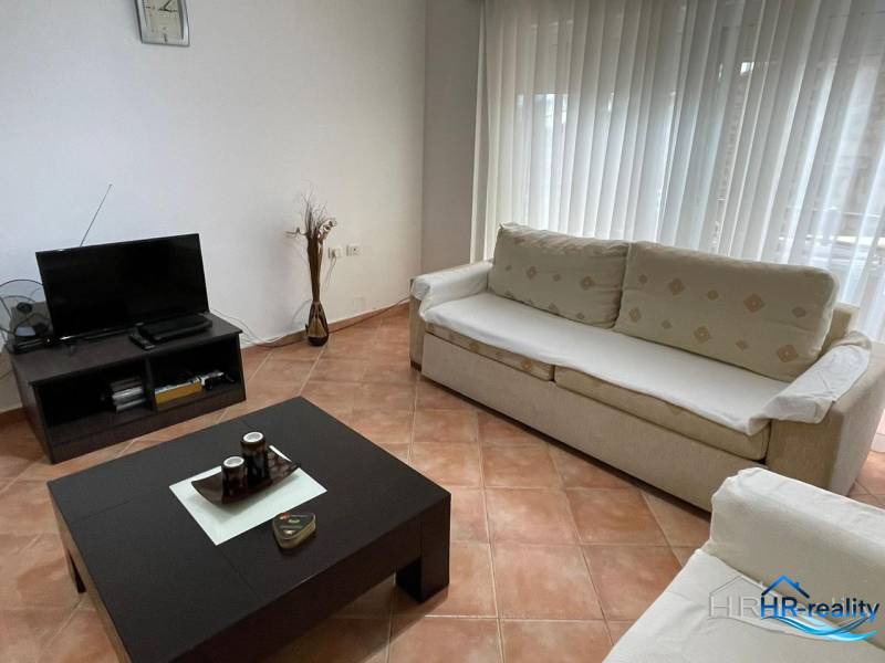 Sarandë - novozariadený apartmán v tesnej blízkosti mora - Obývacia izba v rekreačnom apartmáne s pohovkami, stolíkom a televízorom.