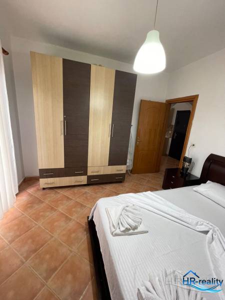 Sarandë - novozariadený apartmán v tesnej blízkosti mora - Svetlá spálňa v rekreačnom apartmáne s posteľou, šatníkovou skriňou a kachličkovou podlahou.