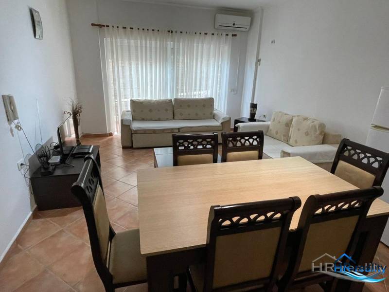 Sarandë - novozariadený apartmán v tesnej blízkosti mora - Obývacia izba s jedálenským stolom a pohovkou v rekreačnom apartmáne.