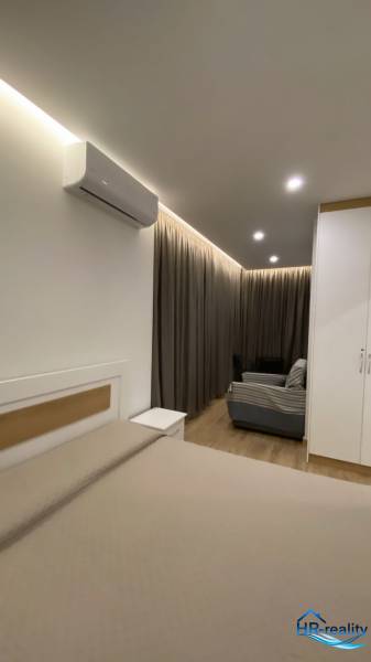 Sarandë - novozariadený apartmán s výhľadom na more - Interiér Rekreačného apartmánu s posteľou, pohovkou, závesmi a klimatizáciou.