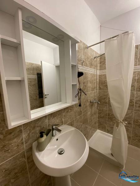 Sarandë - novozariadený apartmán s výhľadom na more - Kúpeľňa v rekreačnom apartmáne s umývadlom, sprchovým kútom a zrkadlom s poličkami.
