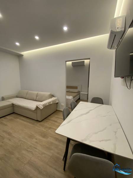 Sarandë - novozariadený apartmán s výhľadom na more - Obývací priestor rekreačného apartmánu s pohovkou, jedálenským stolom a vstupom do spálne.