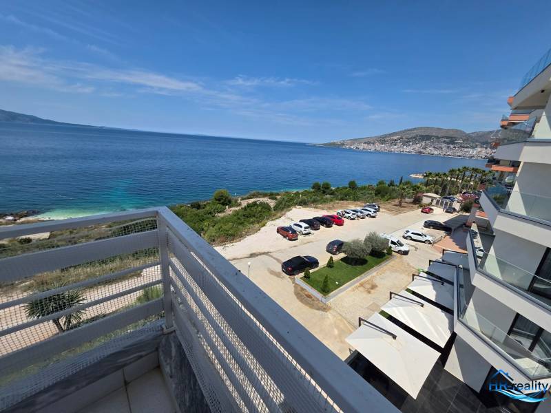 Sarandë - zariadený apartmán s otvoreným výhľadom na more - Pohľad z rekreačného apartmánu v Sarandë na more a parkovisko pri budove.