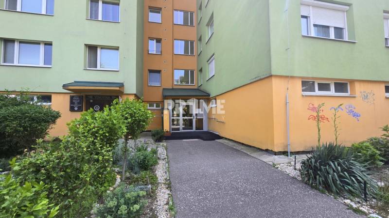 Predaj 3i byt, nepriechodné izby, Osuského ul., BA - Petržalka - Háje - Vstup do bytového domu na Osuského ulici v Bratislave - Petržalke s upravenou zeleňou.