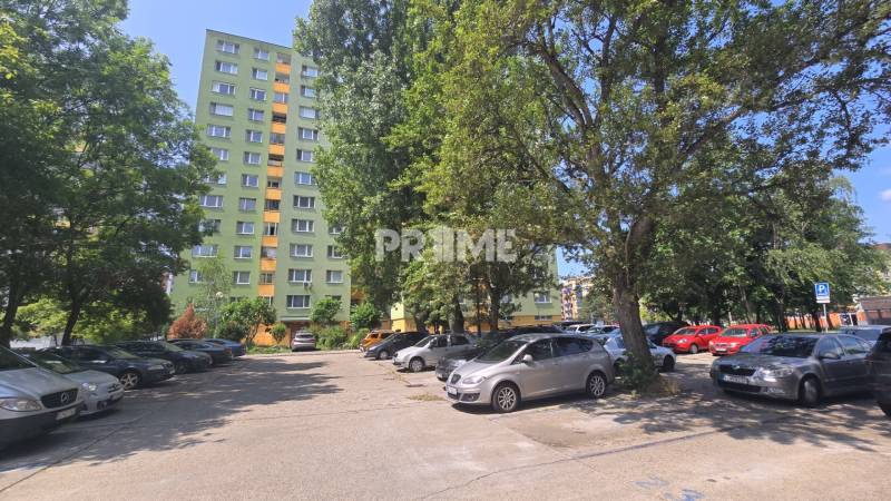 Predaj 3i byt, nepriechodné izby, Osuského ul., BA - Petržalka - Háje - Parkovisko v Bratislave - Petržalke na ulici Osuského s výhľadom na bytové domy и zeleň.