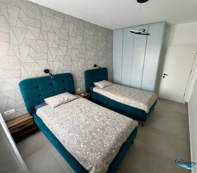 Sarandë - zariadený apartmán, výhľad na more, garážové státie - Dvojlôžková izba s modrými posteľami a vzorovanou stenou v Rekreačnom apartmáne.