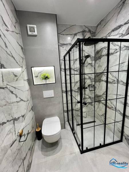 Sarandë - zariadený apartmán, výhľad na more, garážové státie - Kúpeľňa rekreačného apartmánu s toaletou, sprchovým kútom a mramorovými obkladmi.