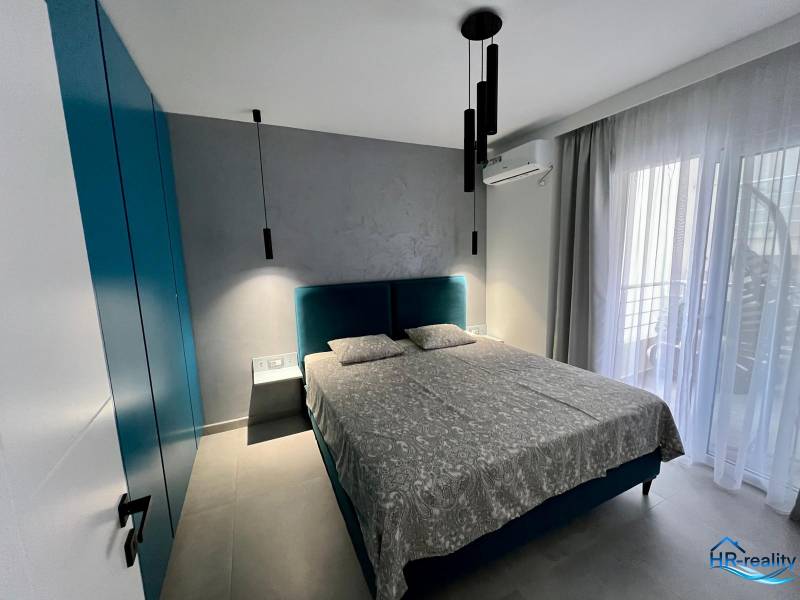 Sarandë - zariadený apartmán, výhľad na more, garážové státie - Izba s pohodlnou posteľou, skriňou, závesmi a balkónovými dverami.
