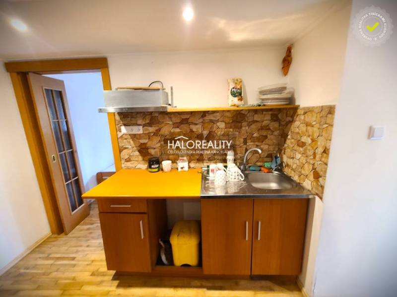 Predaj, rodinný dom Žilina, Budatín - Kuchyňa v rodinnom dome s dreveným nábytkom a kamenným obkladom.
