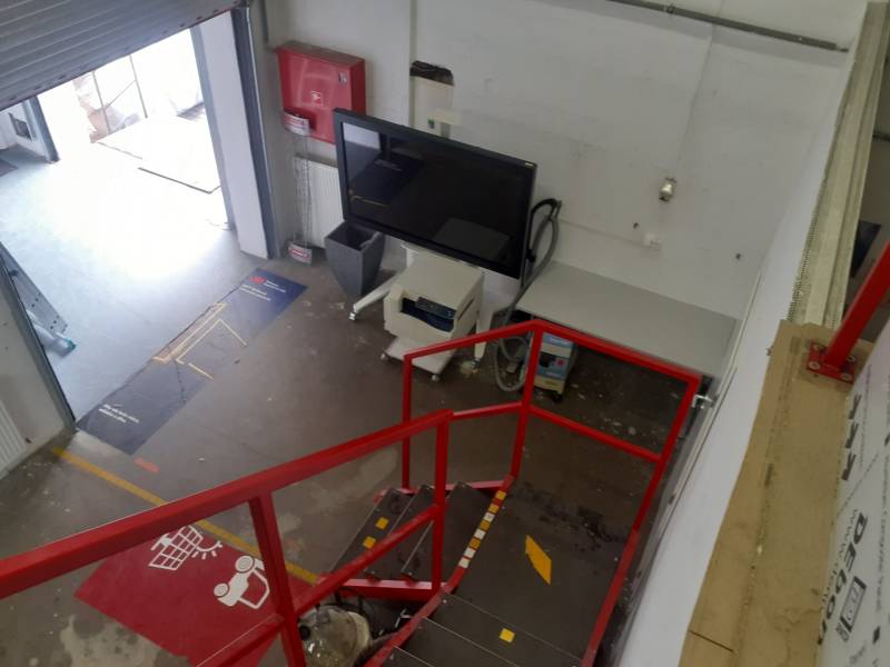 Prenájom skladu 150 m2 pri Zlatých pieskoch na Studenej ul. - V skladoch a halách je červené schodisko, obrazovka a otvorený vstupný priestor.
