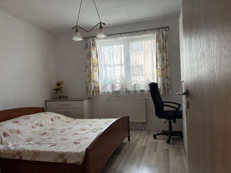 Priestranný rodinný dom v Malackách + pozemok na výstavbu RD v cene - Spálňa s posteľou, pracovnou stoličkou a komodou v rodinnom dome.