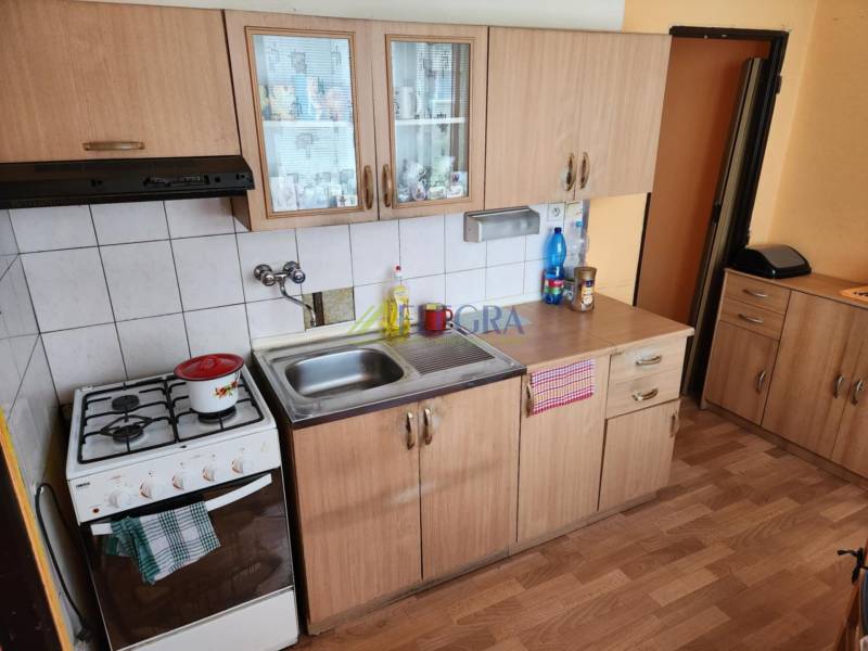 REZERVOVANÝ- 1-izbový byt, Košice, Ružová ulica - Kuchyňa v 1-izbovom byte s drevenými skrinkami a plynovým sporákom.