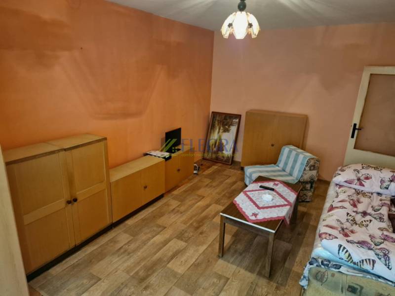 REZERVOVANÝ- 1-izbový byt, Košice, Ružová ulica - Izba s dreveným nábytkom a kreslom v 1-izbovom byte.