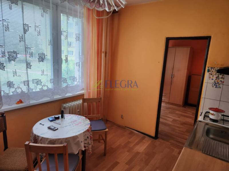 REZERVOVANÝ- 1-izbový byt, Košice, Ružová ulica - Kuchyňa v 1-izbovom byte so stolom, stoličkami a záclonami na okne.