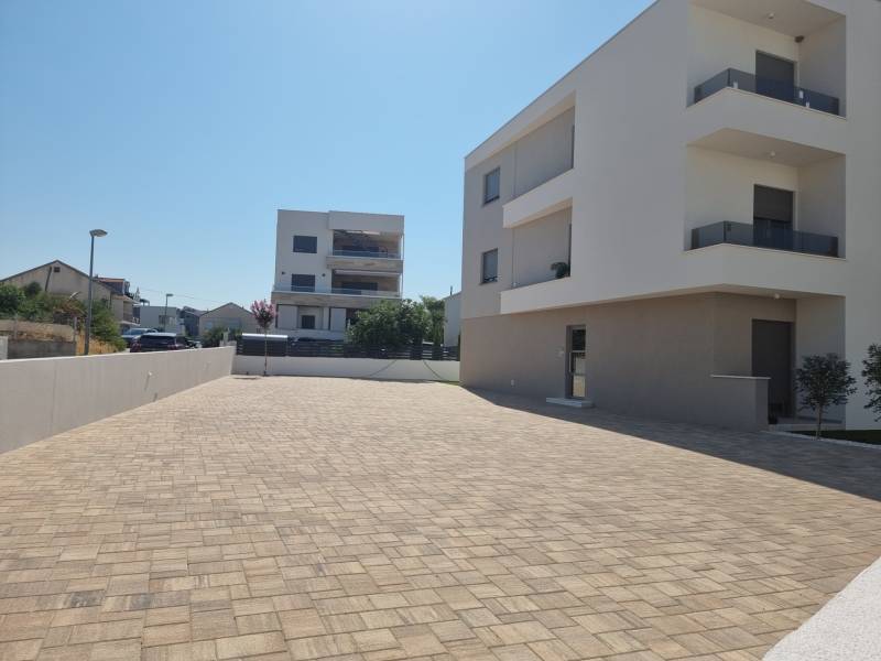 CHORVÁTSKO - Pekné apartmány 350m od pláže (S1) - VODICE - Vo Vodiciach sú viditeľné moderné bytové budovy a dláždená prístupová cesta.
