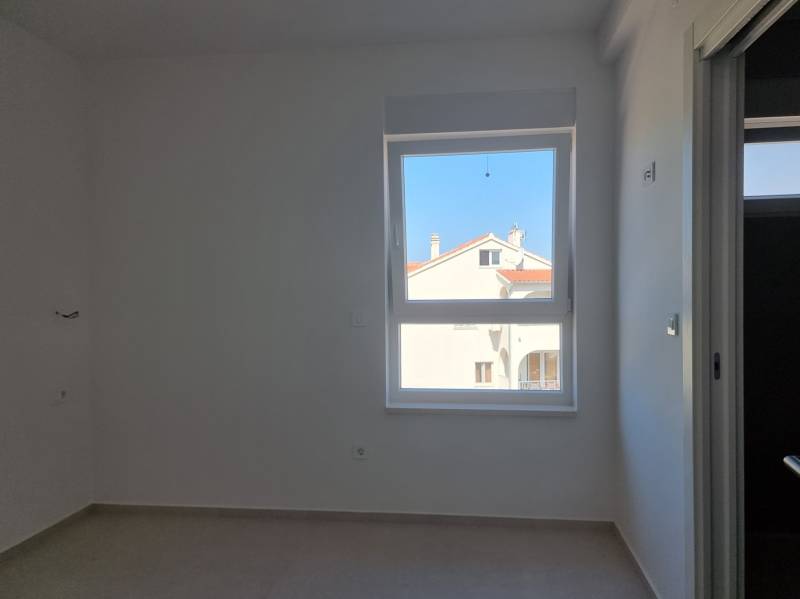 CHORVÁTSKO - 4 izbové apartmány s priestrannými pivnicami - VODICE - Izba v 4-izbovom byte s výhľadom na záhradu, svetlé steny, okno.