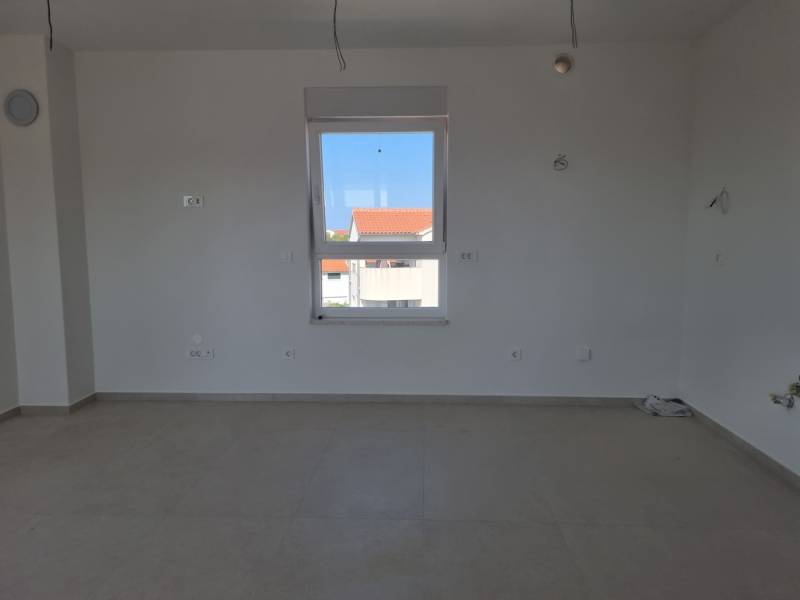 CHORVÁTSKO - 4 izbové apartmány s priestrannými pivnicami - VODICE - Svetlá miestnosť s bielymi stenami a oknom v 4-izbovom byte.