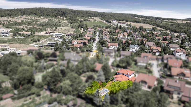 Dom pre náročného klienta, ktorý vie oceniť kvalitu –  Limbach - Pohľad na rodinné domy v Limbachu obklopené zeleňou a kopcami v pozadí.
