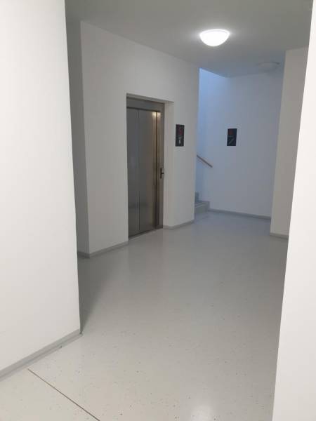 Nový moderný byt s balkónom a parkovaním v širšom centre. Jarabinková - Chodba s výťahom a schodiskom v bytovom dome, 2-izbový byt.