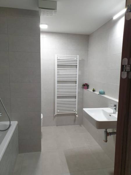 Nový moderný byt s balkónom a parkovaním v širšom centre. Jarabinková - Kúpeľňa v 2-izbovom byte s vaňou, umývadlom a rebríkovým radiátorom.