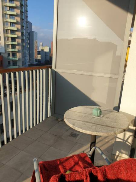Nový moderný byt s balkónom a parkovaním v širšom centre. Jarabinková - Balkón 2-izbového bytu s výhľadom na mesto a jednoduchým stolom.
