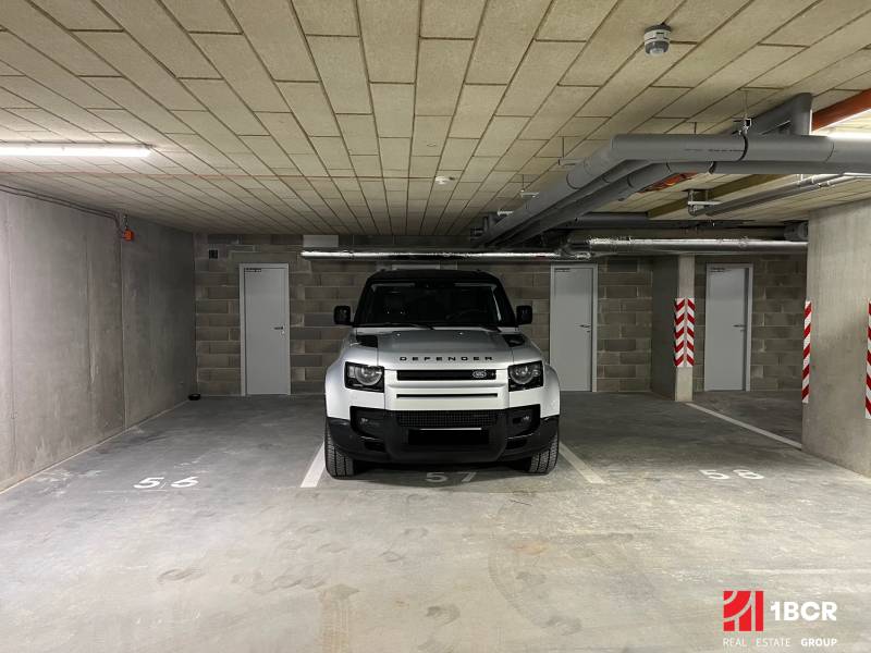 PARKOVACIE STÁTIE + KOBKA - PRI ŠAJBÁCH, BRATISLAVA - RAČA - Auto parkujúce v garáži s dverami a číslovaním na podlahe.