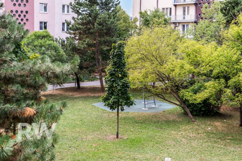 REWIN I VÝNIMOČNÝ 2-IZBOVÝ BYT NA PRENÁJOM! - Park v Bratislave na Československých parašutistov s lavičkou a zeleňou, obklopený bytovými domami.