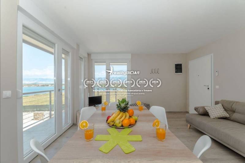 POVLJANA - dvojizbový apartmán - 1. rad k moru - Rekreačný apartmán s veľkým stolom, výhľadom na more, ovocím a pohármi džúsu.