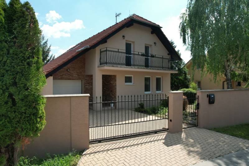 Slnečný 5 izbový dom v Zálesí s veľkým pozemkom - Rodinný dom v Zálesí na ulici Zálesie s balkónom, bránou a záhradou.