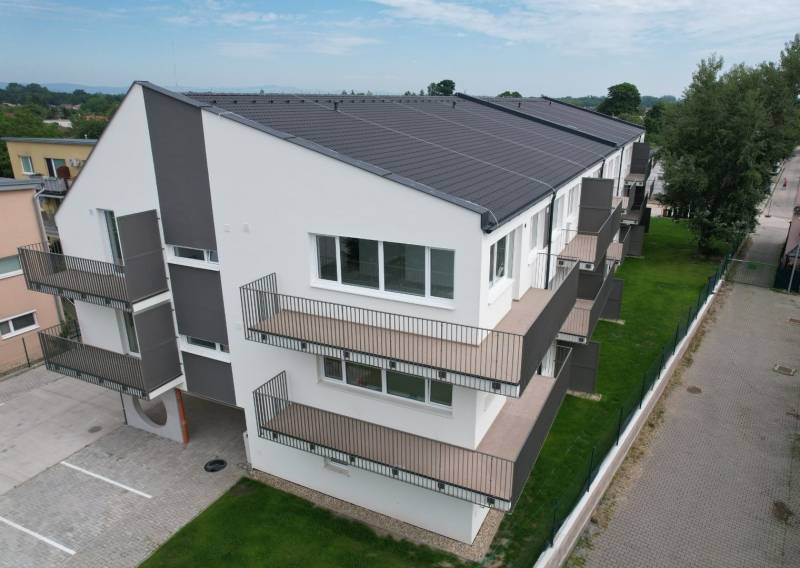 Nadštandardný 3 izbový byt v novostavbe v obci Zálesie - Bytový dom na ulici Muškátová s balkónmi, zeleným trávnikom a parkovacími miestami.