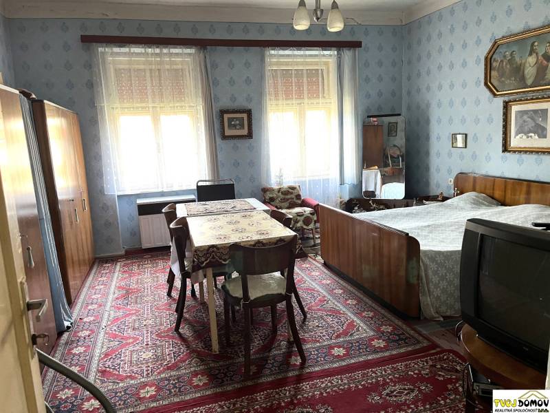 Rodinný dom v Detve na predaj - Spálňa v rodinnom dome s dreveným nábytkom, koberec a dekorácie na stenách.
