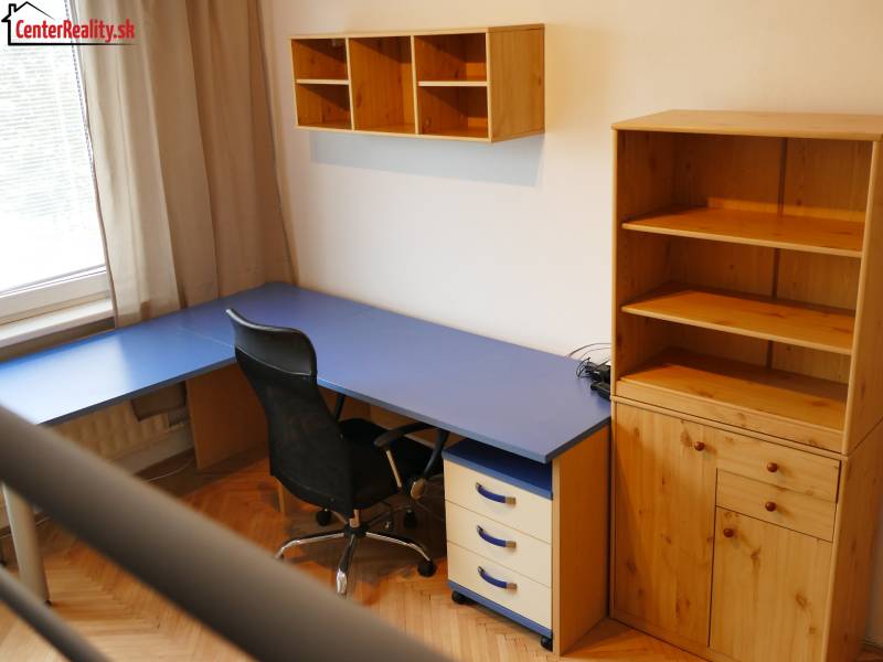 ‼️ 3 IZBOVÝ BYT NA PRENÁJOM, PARTIZÁNSKE-NÁDRAŽNÁ ULICA (ZARIADENÝ)‼️  - Domáca kancelária s modrým stolom a dreveným úložným nábytkom v 3-izbovom byte.