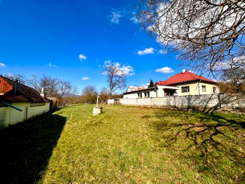Moravské Lieskové - STAVEBNÝ POZEMOK s investičným potenciálom - Výstavba domov v Moravskom Lieskovom, priestranný dvor s trávnikom, modrá obloha.