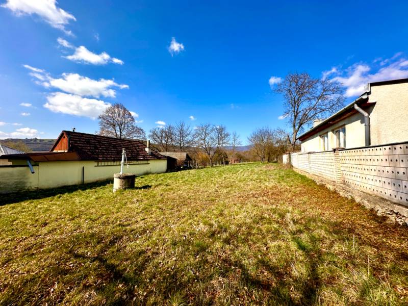 Moravské Lieskové - STAVEBNÝ POZEMOK s investičným potenciálom - Výstavba domov v Moravskom Lieskovom, zobrazené trávnaté pozemky a okolité stavby.