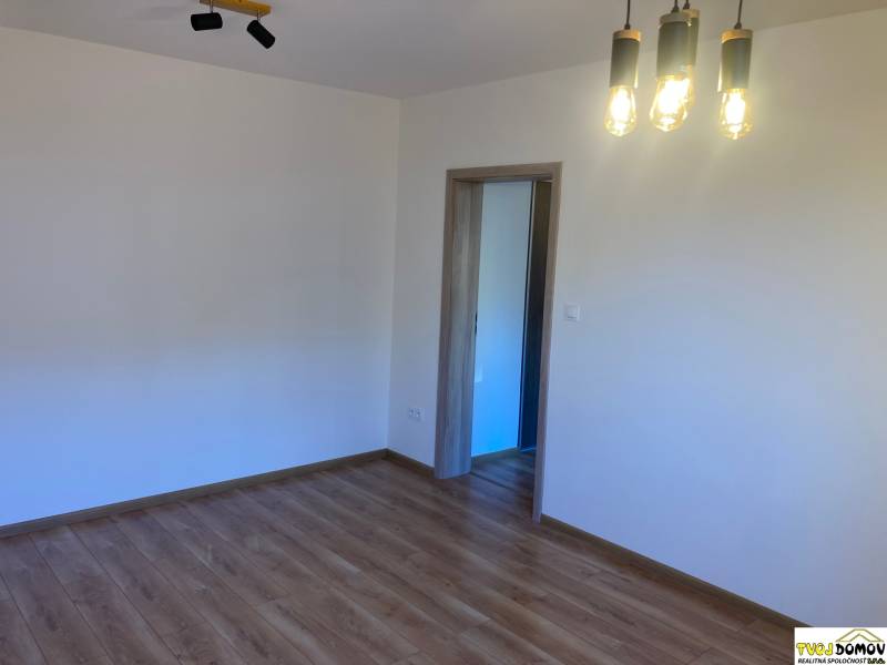 Na prenájom - príjemný 3i byt s balkóm v Detve -kompletná rekoštrukcia - Izba so závesným osvetlením a drevenou podlahou v 3-izbovom byte.