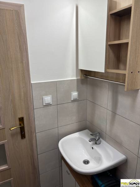 Na prenájom - príjemný 3i byt s balkóm v Detve -kompletná rekoštrukcia - Kúpeľňa v 3-izbovom byte s umývadlom, zrkadlom a drevenými dverami.