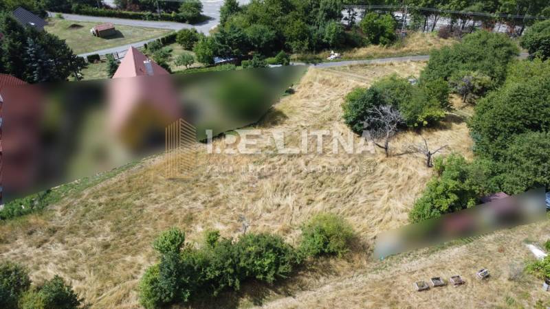 SLNEČNÝ POZEMOK V SRDCI BANSKEJ ŠTIAVNICE, 2 000 M2   - Stavebné pozemky - bývanie v Banskej Štiavnici na SNP, obklopené trávou a stromami.