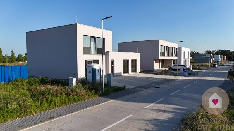 Kráľova pri SENCI-Novostavba 2-podlažného RD s hlinikovými oknami - Rodinné domy na ulici Récka v Kráľovej pri Senci, pred nimi kontajner a toalety.