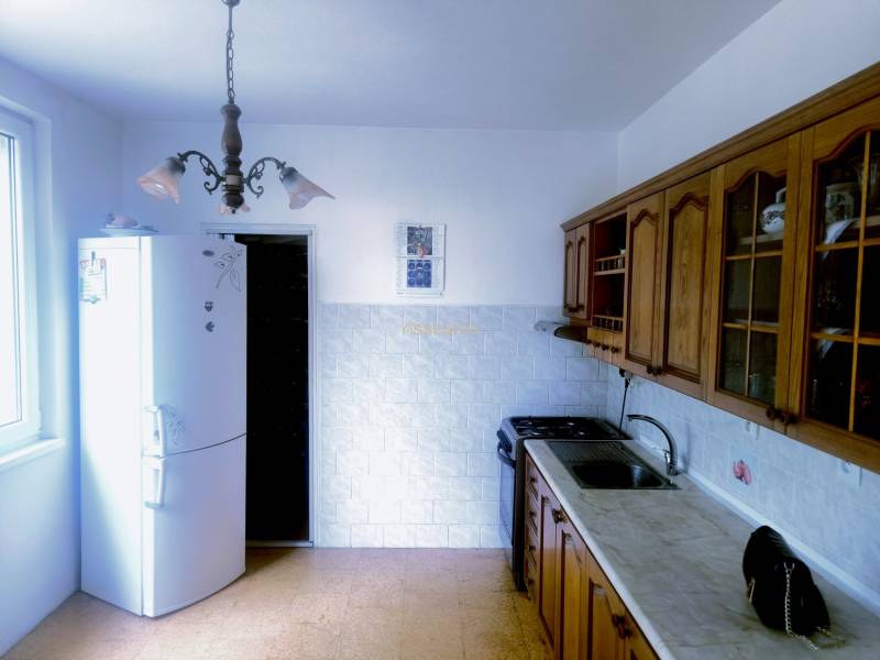  - PREDAJ, 3 IZBOVÝ BYT 82m2, M.R.ŠTEFÁNIKA, LEVICE - Kuchyňa v 3-izbovom byte s rustikálnymi drevenými skrinkami a bielou chladničkou.