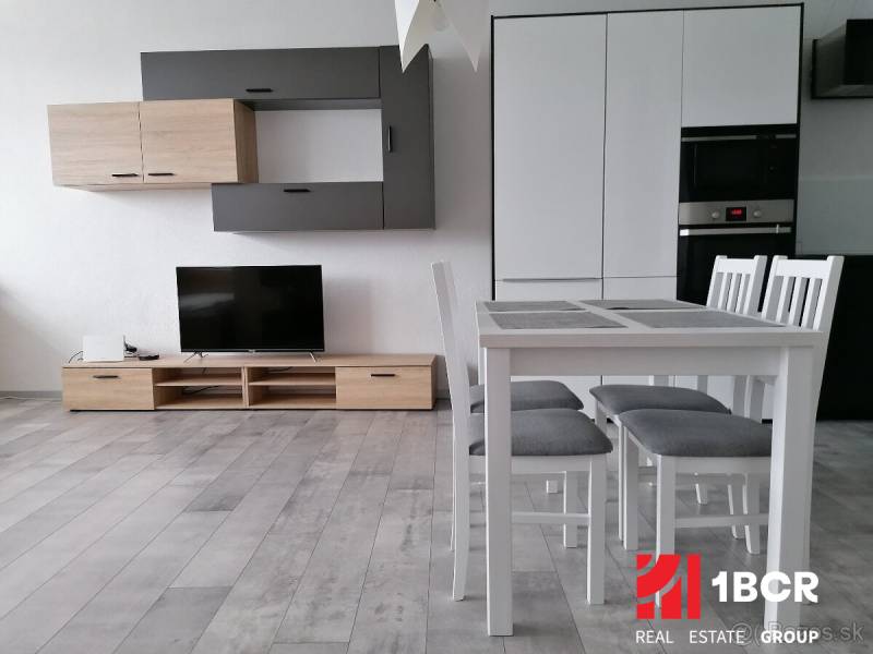 VELKOMETRÁŽNY 1 IZB.AP.BYT- TRNAVSKÁ CESTA, NOVÉ MESTO,BRATISLAVA - Obývacia izba v 1-izbovom byte s televíziou, jedálenským stolom a skrinkami.