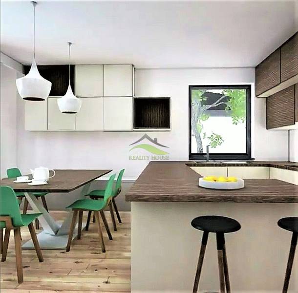Murovaná Novostavba - Rodinný dom s pekný pozemkom 800 m2 - Kuchyňa v rodinnom dome so zelenými stoličkami, drevenou podlahou a veľkým oknom.