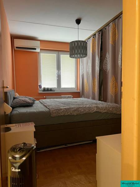 Predaj 3 izbový - Pezinok - Spálňa v 3-izbovom byte s manželskou posteľou, oranžovými stenami a klimatizáciou.