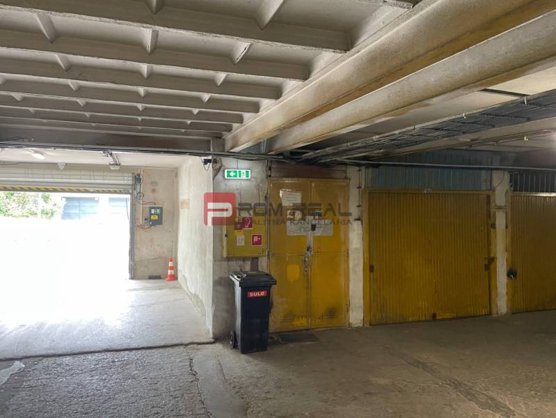 Prenájom garáže v garážovom dome, Pionierska, Bratislava - Nové Mesto - Garáže so žltými dverami, odpadkovým košom a východom, interiér.