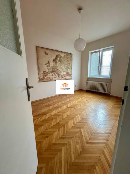 2 - izbový byt na prenájom v meste Nitra pod Nitrianskym hradom  - Izba v 2-izbovom byte s parketami a mapou na stene.