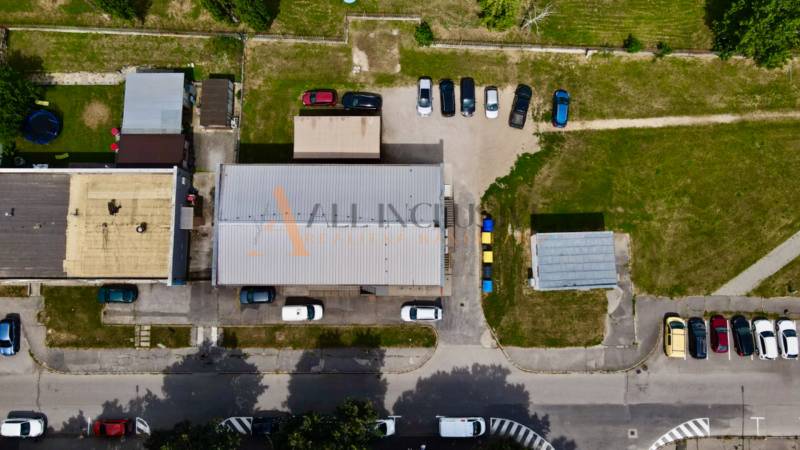 INVESTIČNÝ KOMERČNÝ OBJEKT | TOPOĽČANY  - Letecký pohľad na strechy budov a parkovisko v obchodných priestoroch Topoľčian na Janka Matušku.