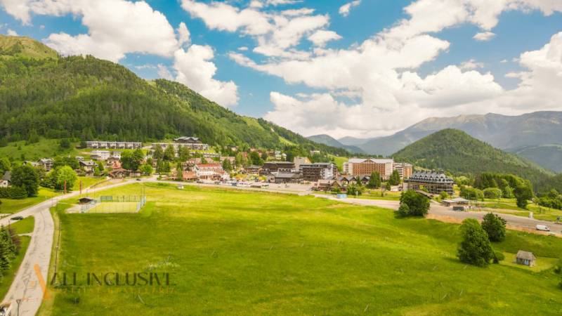 PRIESTRANNÝ 3 IZBOVÝ BYT S TERASOU | DONOVALY  - Panorama Donovaly, obklopená lúkami a horami, z výšky zobrazuje 3-izbové byty.