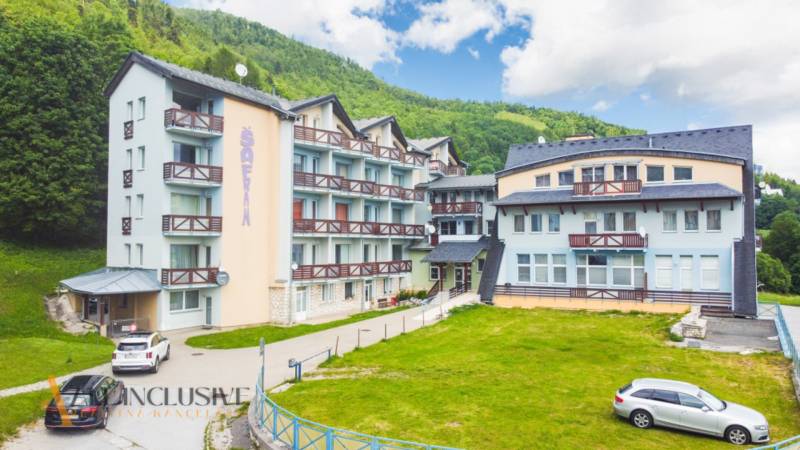 2 IZBOVÝ BYT S PANORAMATICKÝM VÝHĽADOM NA DONOVALY - Budova so štyrmi podlažiami a balkónmi na ulici Šafrán v Donovaloch.