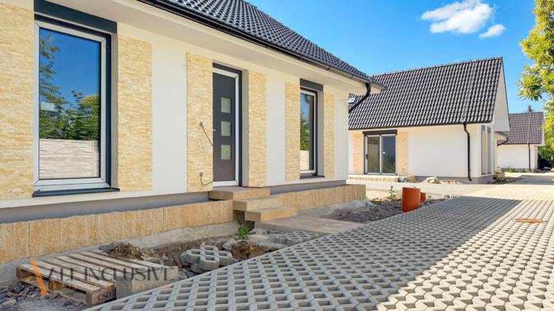 NOVINKA!!! MODERNÉ NOVOSTAVBY NA KĽÚČ | ZLATÉ MORAVCE  - Rodinný dom na Vajanského ulici v Zlatých Moravciach so svetlou fasádou a zámkovou dlažbou.